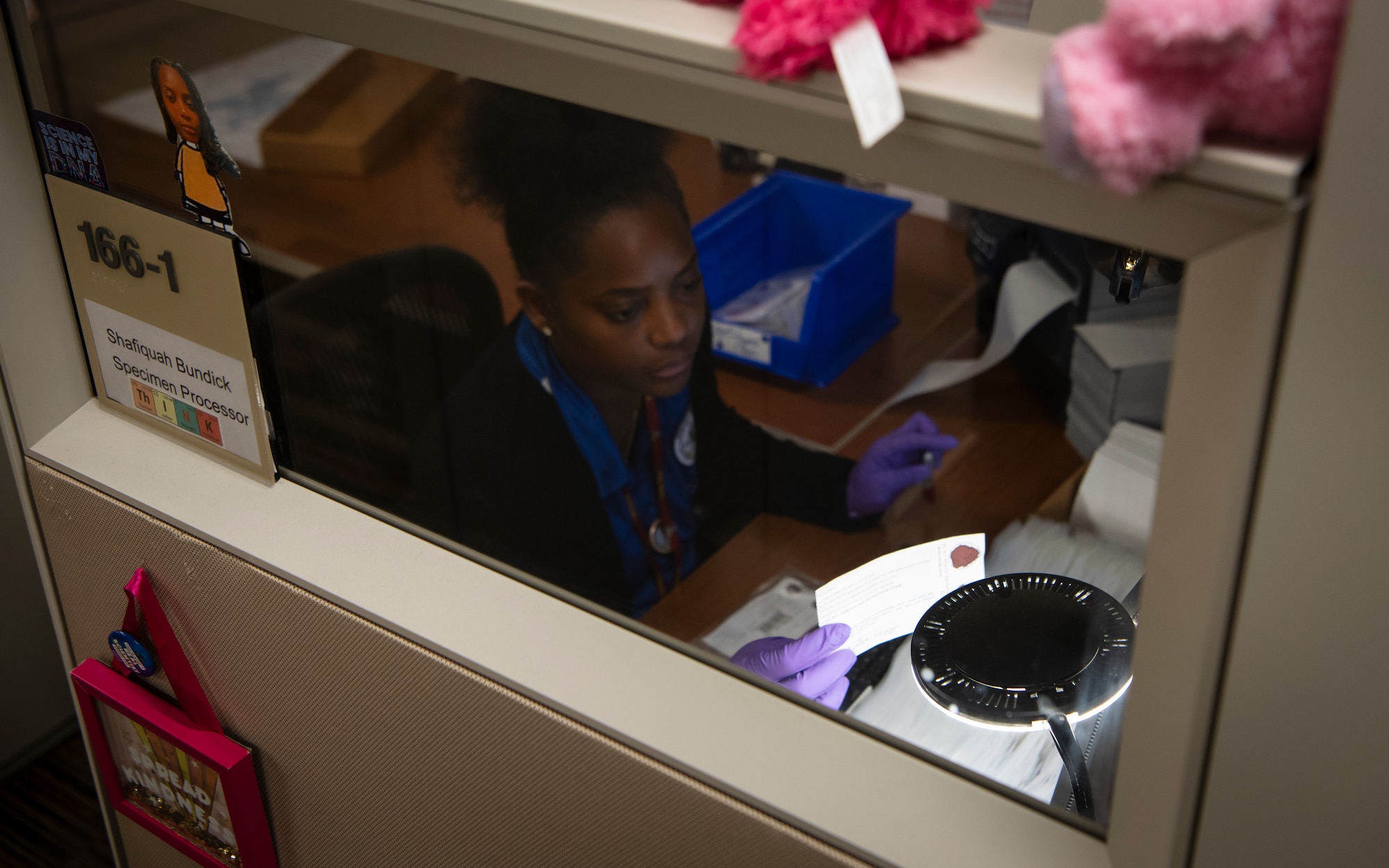 Ms. Shafiquah Bendick, Armed Forces Repository of Specimen Samples for the Identification of Remains (AFRSSIR) specimen processor, inspects a DNA blood stain card before entering its information into the Specimen Management System at the Armed Forces Medical Examiner System (AFMES), Dover Air Force Base, Delaware, June 26, 2025. The AFRSSIR section is made up of eight employees that are responsible for the collection, processing, and storage of DNA blood stain cards from every U.S. military member as well as certain contractors and civilians. To date, there are over nine million cards stored onsite within AFRSSIR. (U.S. Air Force photo by Staff Sgt. Noah D. Coger)