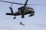 Alaska Air National Guard HH-60G Pave Hawk aviators and Guardian Angels, assigned to the 210th and 212th Rescue Squadrons, respectively, conduct a hoist rescue demonstration while participating in a multi-agency hoist symposium at Bryant Army Airfield on Joint Base Elmendorf-Richardson, Alaska, July 22, 2025.