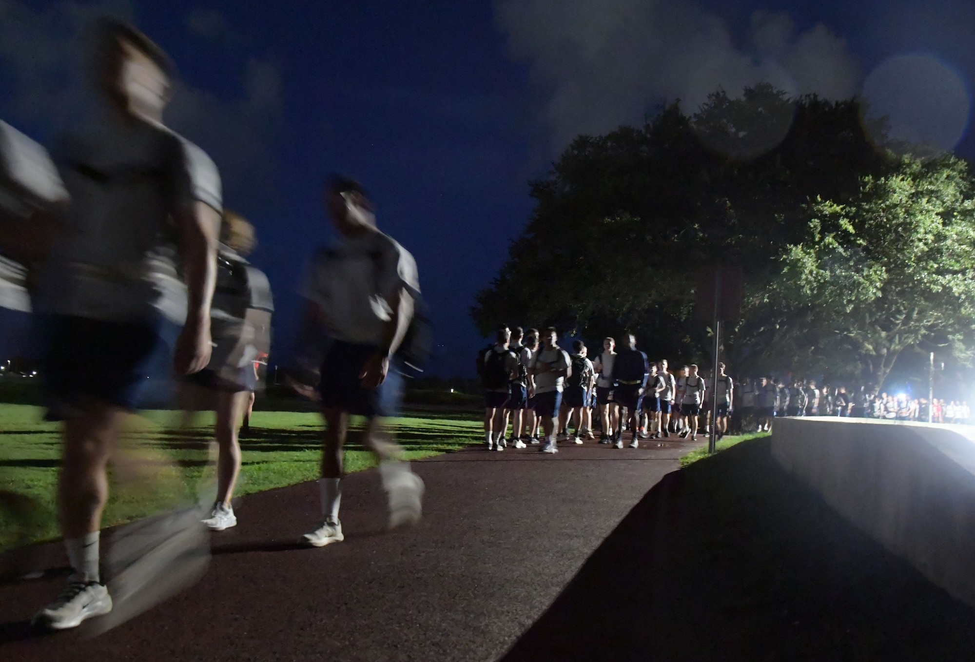 Airmen walking and running with heavy bags.