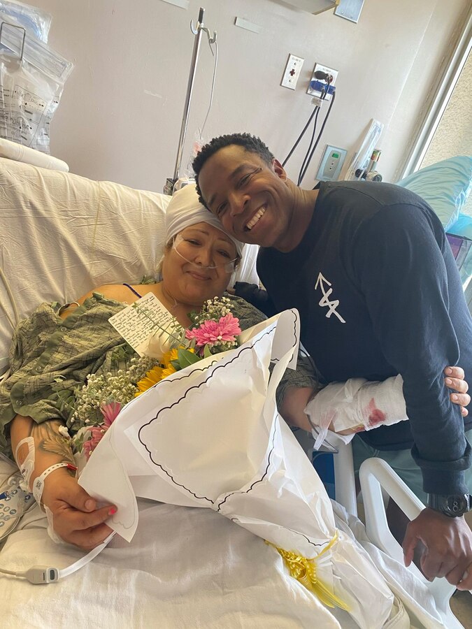 U.S. Navy Hospital Corpsman 2nd Class Sammuel Goodwin, a hospital corpsman with 1st Marine Regiment, 1st Marine Division, poses for a photo with Melinda Gurrola at Hillcrest Medical Center at University of California San Diego Health Hospital, California. Gurrola was in a motorcycle crash that left her severely injured on the I-805 north. After seeing the scene of the crash, Goodwin used his medical training to treat Gurrola's injuries and assisted paramedics in getting her to the hospital for further treatment. Goodwin's selflessness and quick medical intervention helped save Gurrola's life. Goodwin is a native of Queens, New York. (U.S. Marine Corps courtesy photo)