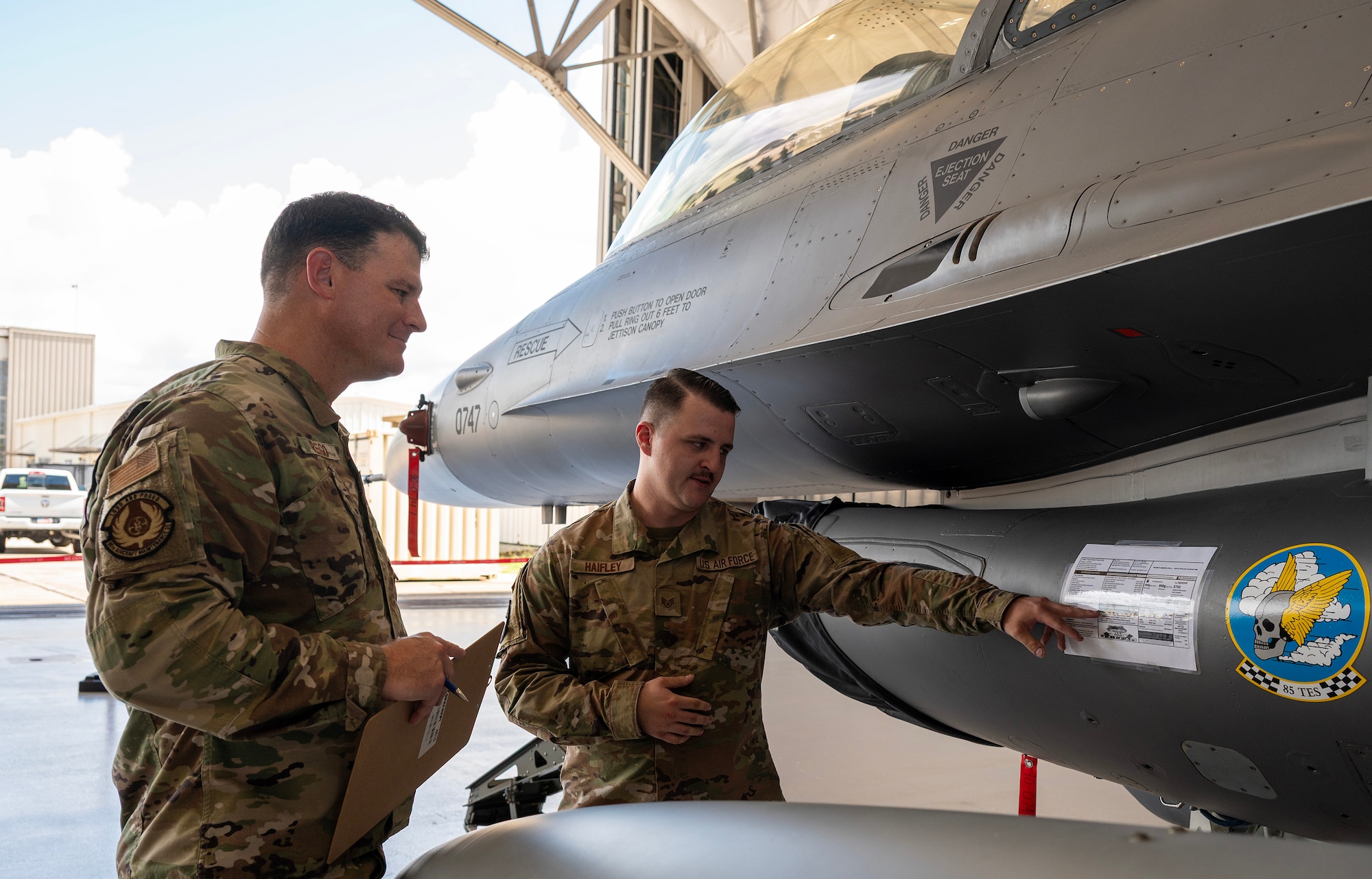 A unit crew chief explains to an aircraft maintenance member a personalized fact sheet on his aircraft as part of the dedicated crew chief competition.