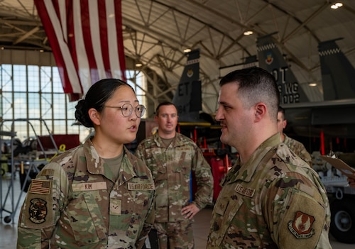 Airmen discuss the answer to a general maintenance knowledge question asked by the judges.