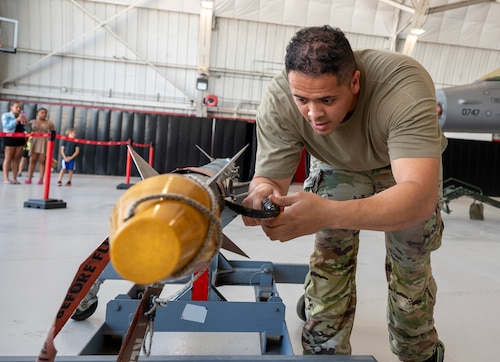 A load crew member inspects an AIM-9X Sidewinder.