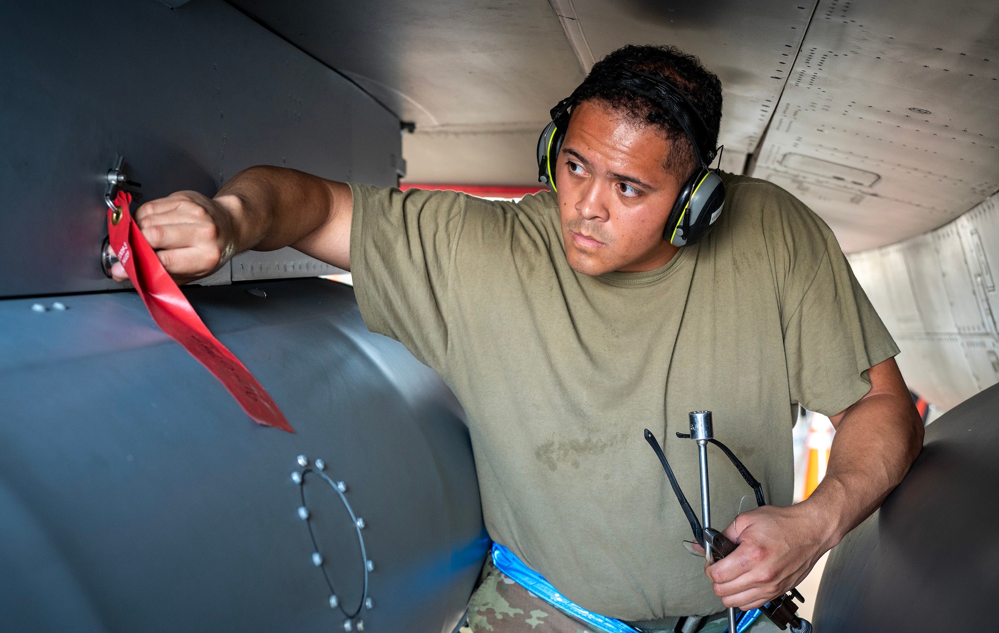 Airman installs impulse cartridges onto F-16 Fighting Falcon.