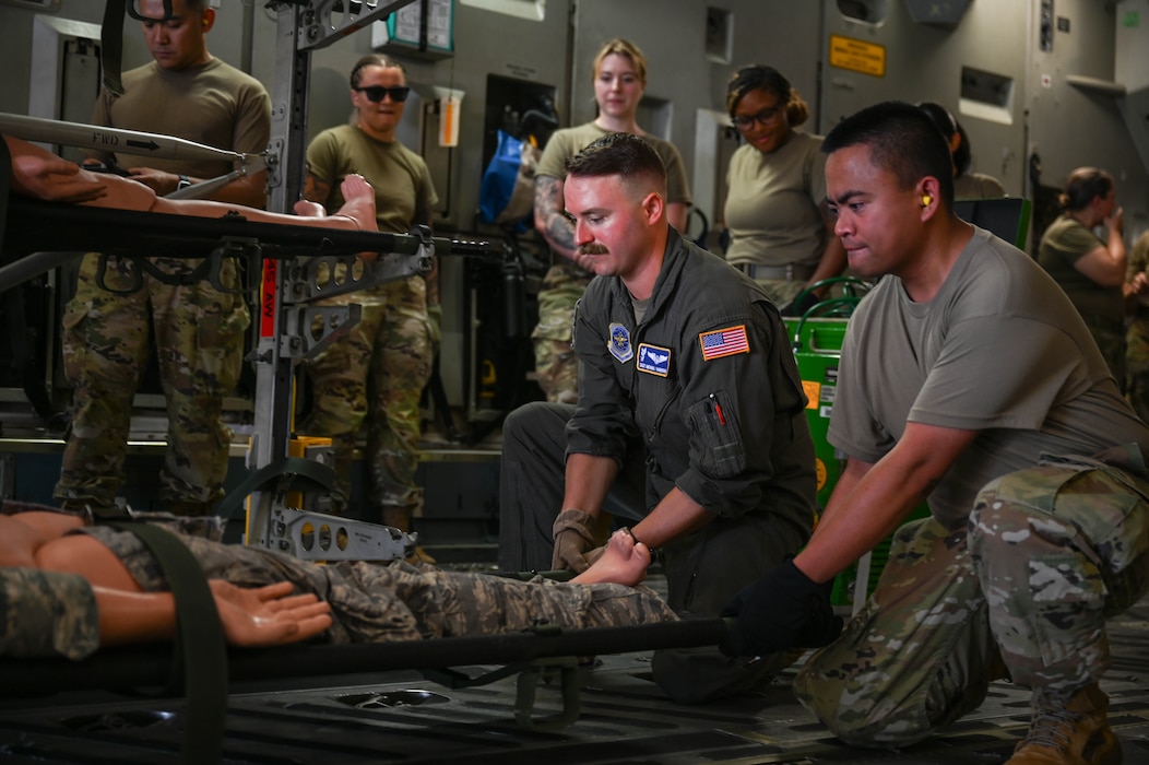Airmen work on securing a litter aboard a C17 Globemaster III.