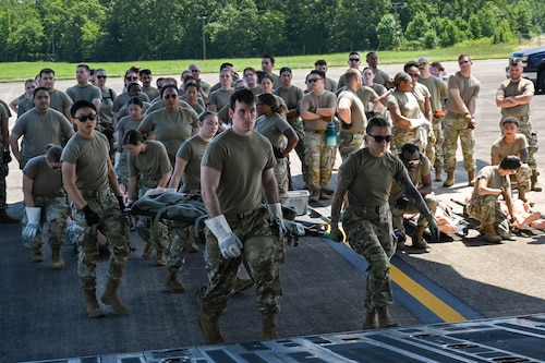 Airmen transport a stretcher up the ramp of a C17 Globemaster III.