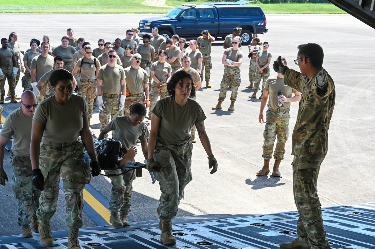 Airmen carry a stretcher up the ramp of a C17 Globemaster III