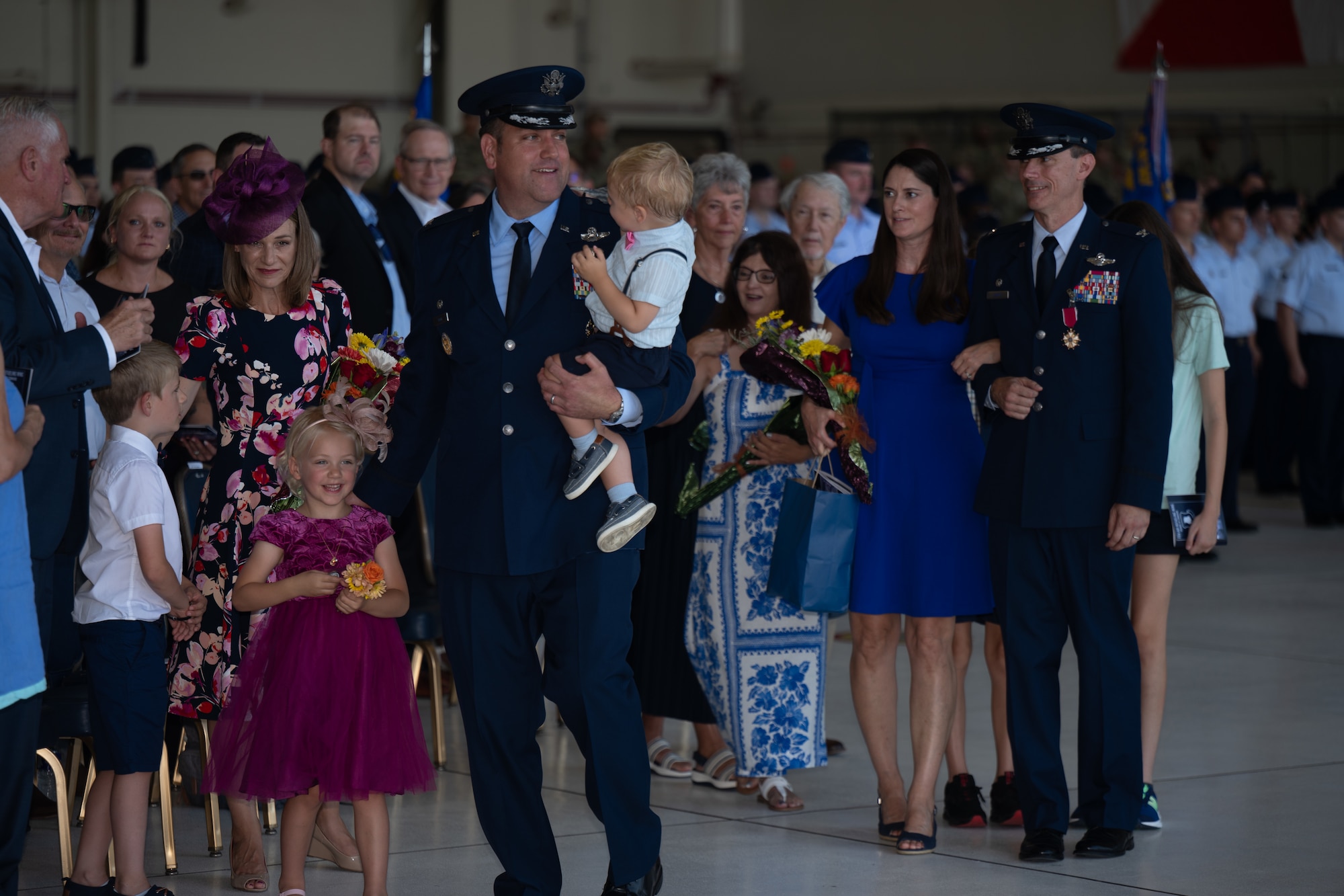 Col. Joe Wall, 22nd Air Refueling Wing commander, and Col. Cory Damon, former 22nd ARW commander, walk with their families following the 22nd ARW change of command ceremony at McConnell Air Force Base, Kansas, July 28, 2025. The ceremony concluded with Wall and Damon reconvening with their loved ones and exiting the venue. (U.S. Air Force photo by Senior Airman Amelio Brown)