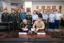 U.S. Marine Corps Maj. Gen. George Rowell, USINDOPACOM director of Strategic Planning and Policy (J5), and Cambodian Lt. Gen. Suon Samnang, chairman of the Military Cooperation Coordination Group, sign a document during a Bilateral Defense Dialogue at USINDOPACOM headquarters on Camp H.M. Smith in Honolulu, July 24-25, 2025.