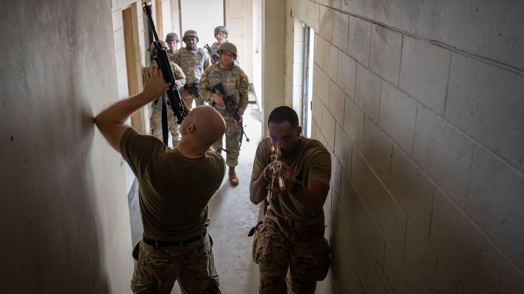 U.S. Air Force Tech. Sgt. Erik Alter, left, 51st Security Forces Squadron wartime operations noncommissioned officer in charge, and Staff Sgt. Nicholas Keys, 51st SFS unit deployment manager, trains Airmen assigned to the 51st Logistics Readiness Squadron and 51st Civil Engineer Squadron, on close quarter battle at Osan Air Base, Republic of Korea, July 24, 2025. Learning how to maneuver as a team and clear buildings in close-quarters environments is an essential aspect of the weapons handling portion of the ability to survive and operate training. (U.S. Air Force photo by Senior Airman Rome Bowermaster)