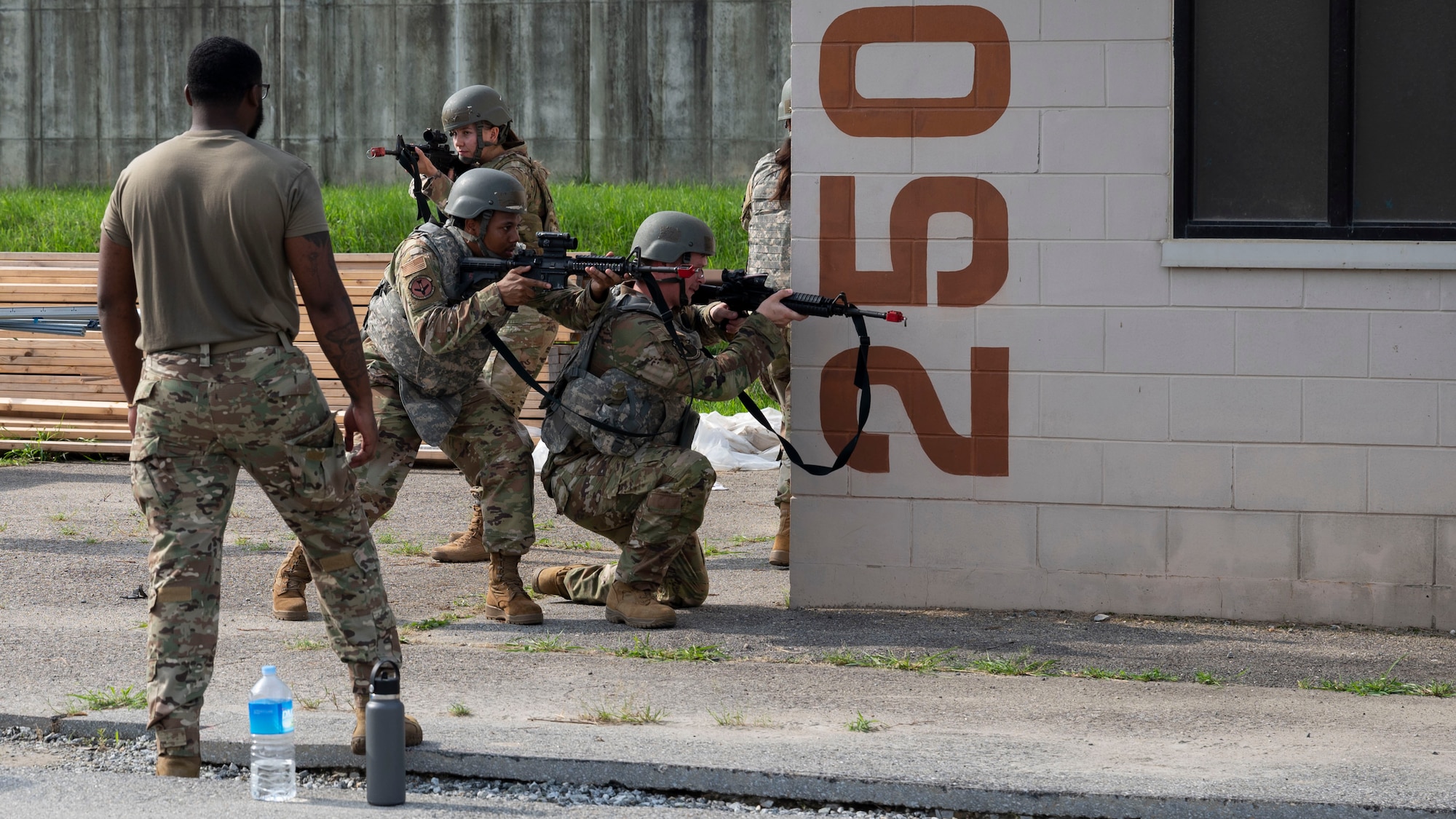 U.S. Air Force Senior Airman Aaron Johnson, left, 51st Security Forces Squadron vehicle noncommissioned officer in charge, trains Airmen on weapons handling and window clearing at Osan Air Base, Republic of Korea, July 24, 2025. Team movement and building-clearing techniques in close-quarters environments are key components of the weapons handling segment of ability to survive and operate training. (U.S. Air Force photo by Senior Airman Rome Bowermaster)