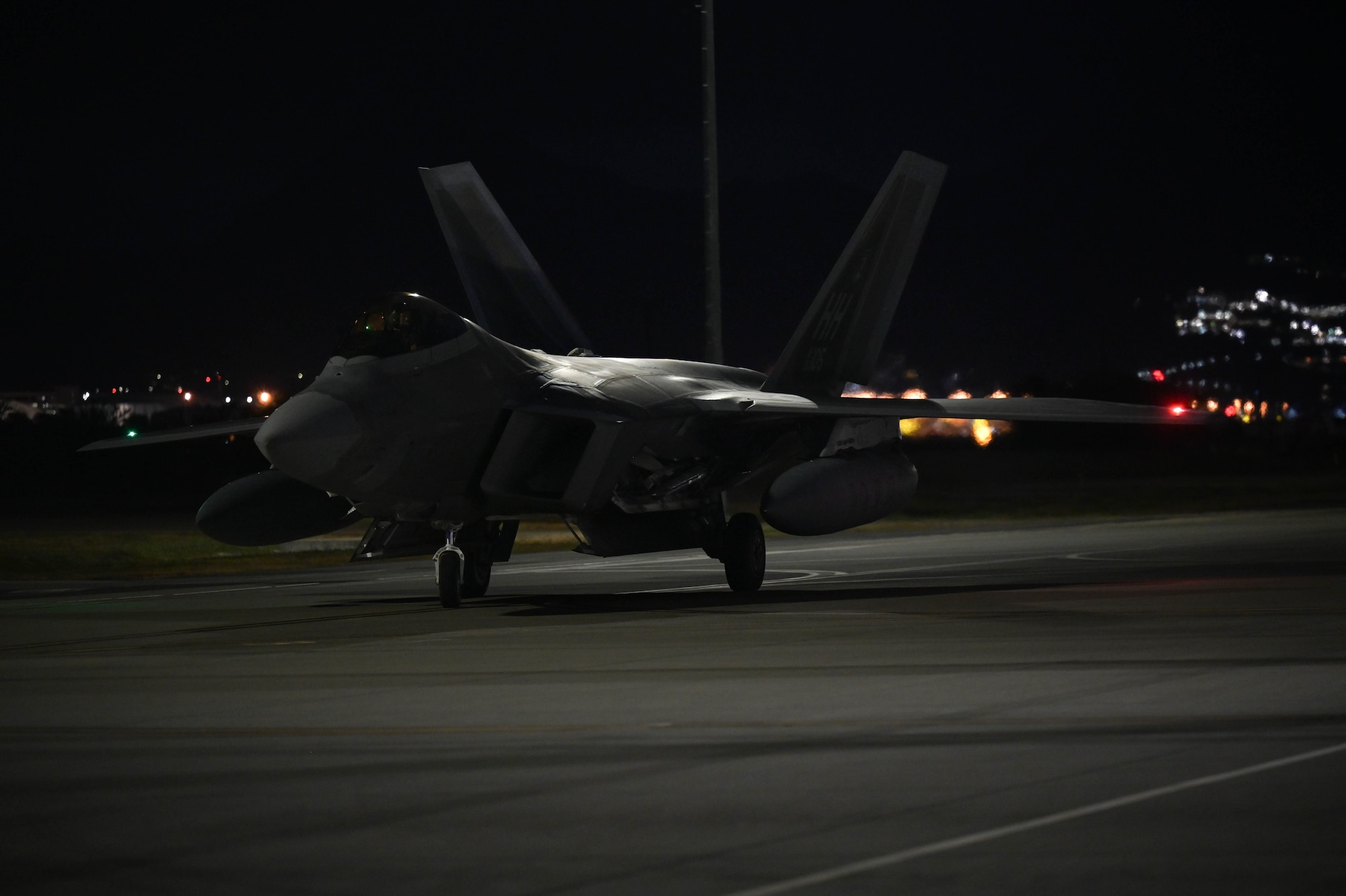An F-22 Raptor taxiing on tarmac.