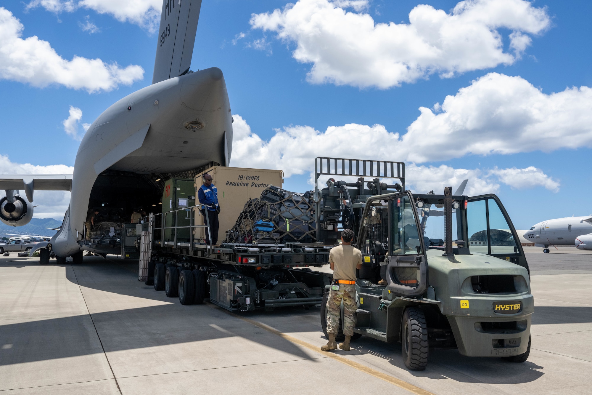 A forklift unloading supplies off of a C-17.
