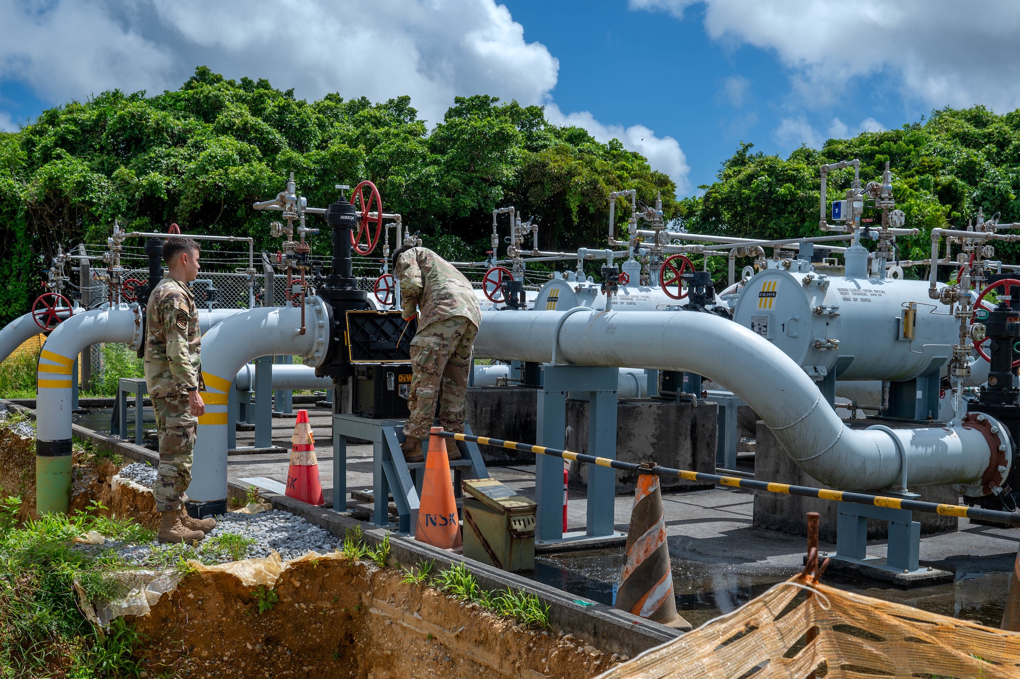 U.S. Air Force Airman 1st Class Tomas Salazar, left, and U.S. Air Force Airman 1st Class Gage Chinel, 18th Logistics Readiness Squadron laboratory technicians, gather raw fuel samples from the Defense Logistic Agency pipeline.