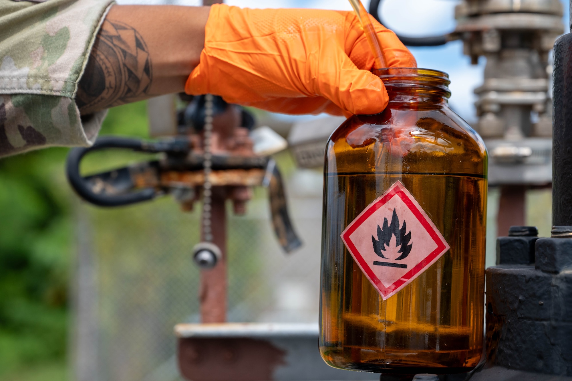 U.S. Air Force Airman 1st Class Gage Chinel, 18th Logistic Readiness Squadron laboratory technician, collects fuel samples from a Defense Logistic Agency pipeline.