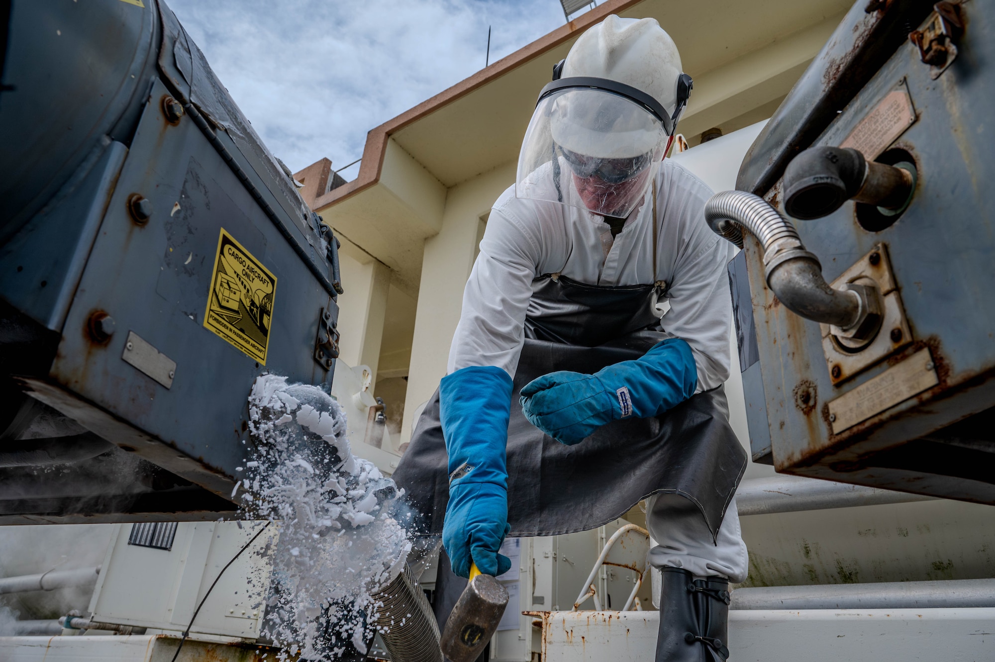 U.S. Marine Corps Lance Cpl. Michael Mallette, 9th Engineer Support Battalion fuel technician, hits an oxygen cart to remove ice debris.