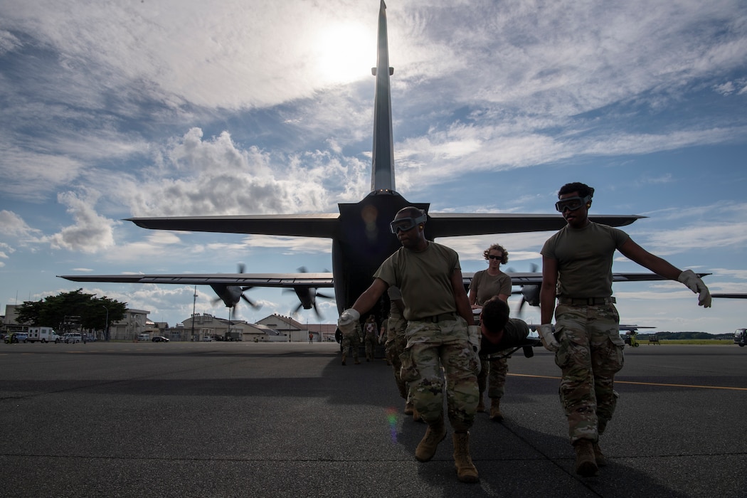 U.S. Air Force Airmen assigned to the 35th Medical Group execute an engine-running offload of a simulated litter patient for a mass casualty exercise.