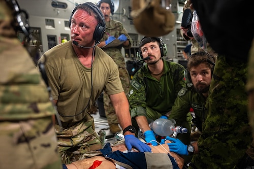 U.S. Air Force and Royal Canadian Air Force aeromedical evacuation members participate in a familiarization training on a U.S. Air Force C-17 Globemaster III aircraft assigned to the 60th Air Mobility Wing, during the Air Force's 2025 Department-Level Exercise series at Andersen Air Force Base, Guam, July 13, 2025. This exercise is part of the first-in-a-generation DLE series, a new way of conducting operations in a contested, dynamic environment to build capabilities making a stronger, more deterrent force. The DLE series encompasses all branches of the Department of Defense, along with Allies and partners, employing more than 400 Joint and coalition aircraft and more than 12,000 members at more than 50 locations across 3,000 miles. (U.S. Air Force photo by Senior Airman Brooklyn Golightly)