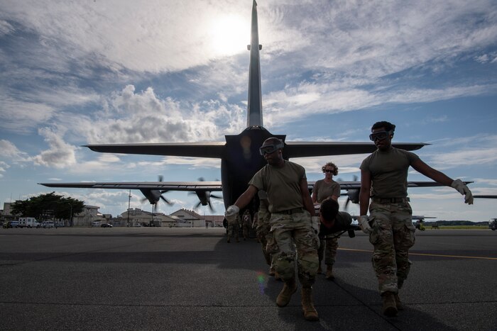 U.S. Air Force Airmen assigned to the 35th Medical Group execute an engine-running offload of a simulated litter patient for a mass casualty exercise.