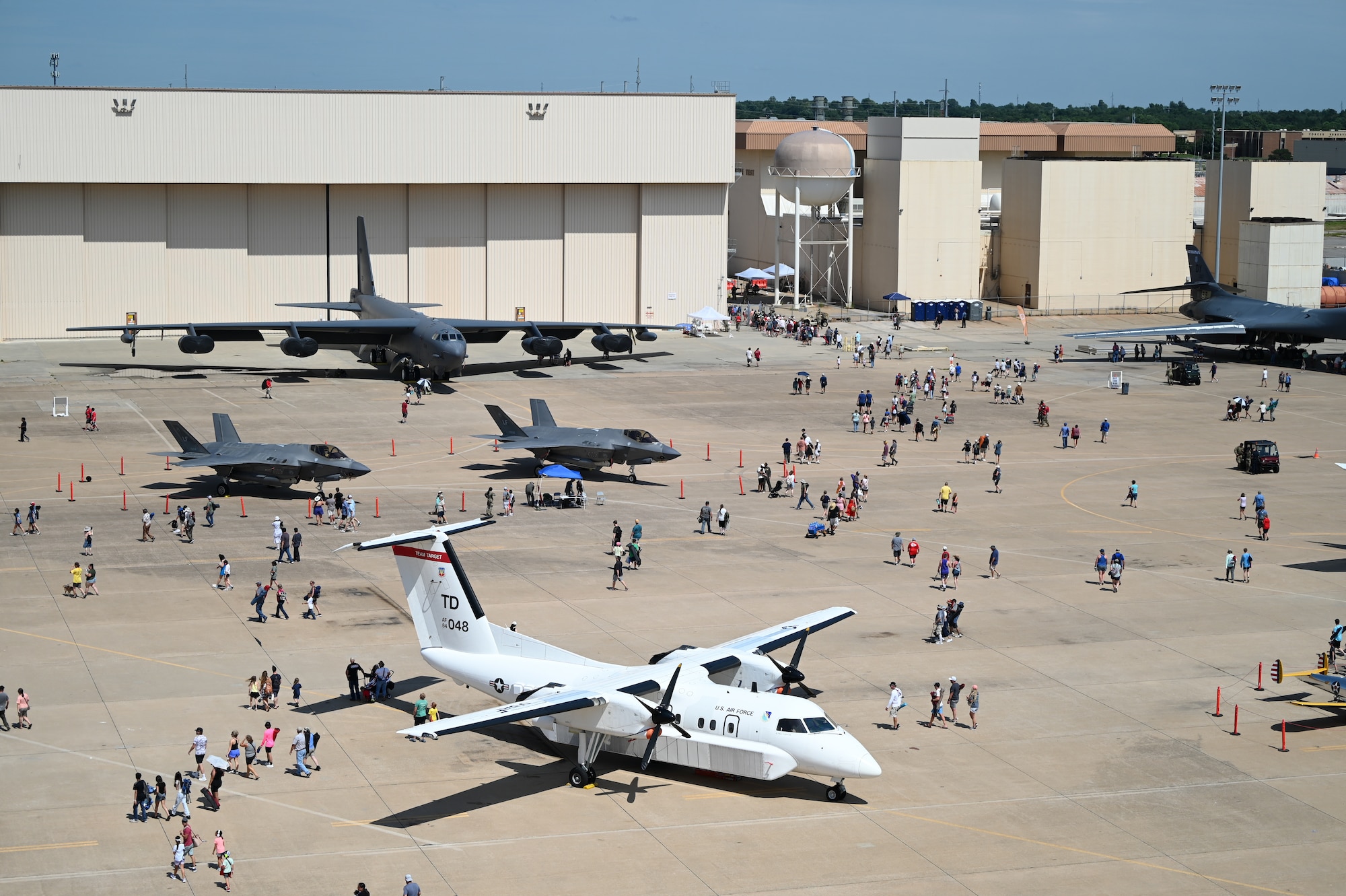 People walking around air show.