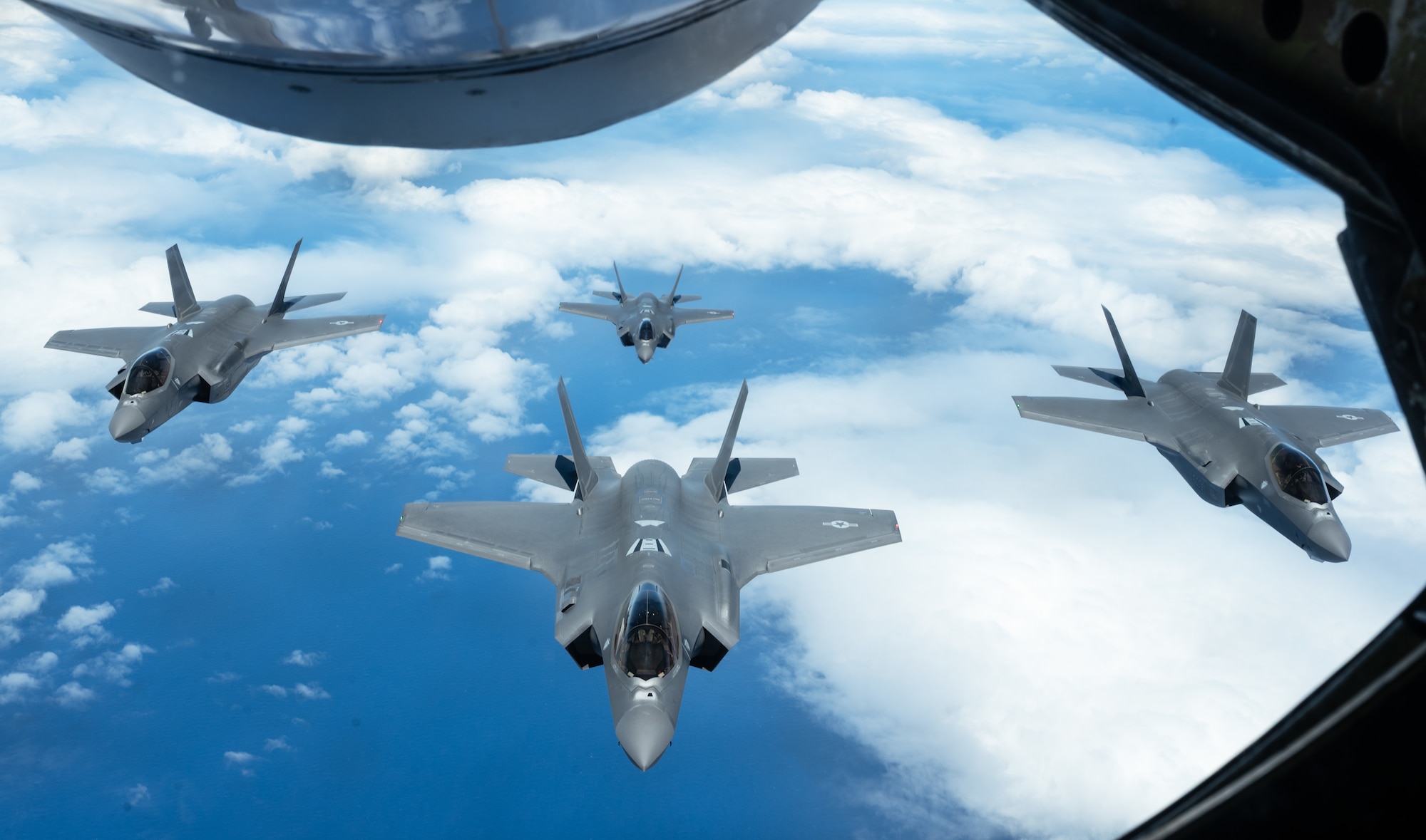 Four F-35 Lightning II aircraft assigned to the 176th Fighter Squadron, Wisconsin Air National Guard, fly behind a KC-135 Stratotanker aircraft over the Pacific Ocean, July 11, 2025. This flight mission is part of the U.S. Air Force's 2025 Department-Level Exercise series, designed to strengthen and showcase its ability to operate at speed and scale, sustain prolonged operations, and rapidly shift across any theater. The DLE series encompasses all branches of the Department of Defense, along with Allies and partners, employing more than 400 joint and coalition aircraft and more than 12,000 personnel across more than 50 locations across 3,000 miles. (U.S. Air Force photo by Staff Sgt. Tryphena Mayhugh)