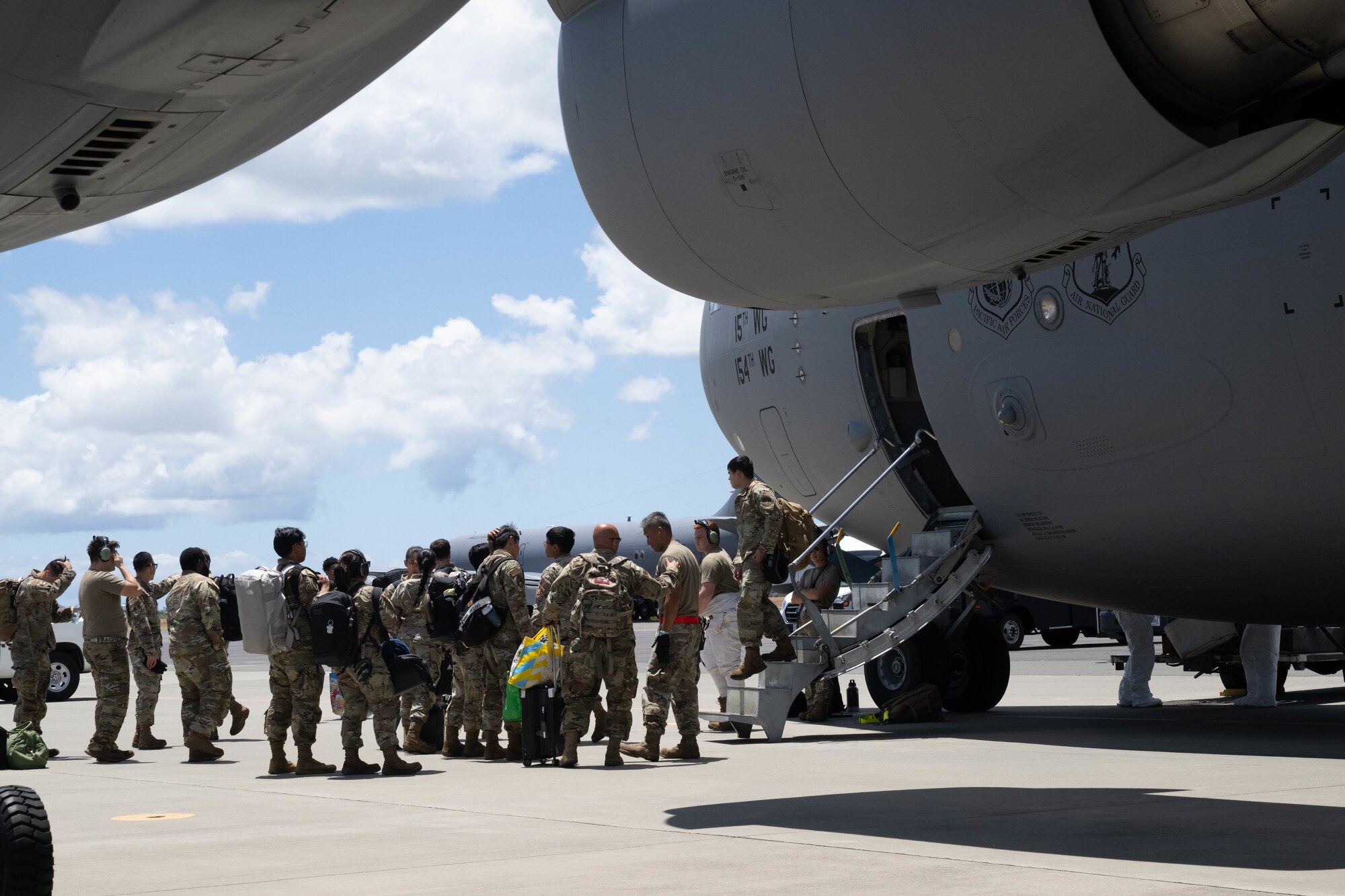 A group of Airmen outside the side door of a C-17.