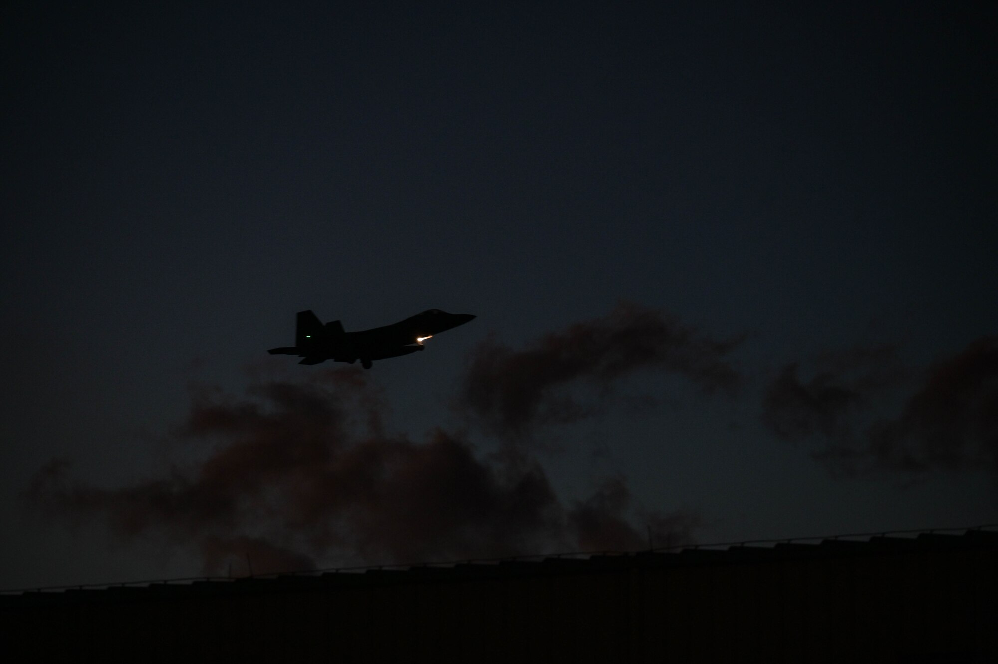 An F-22 Raptor landing during the night.