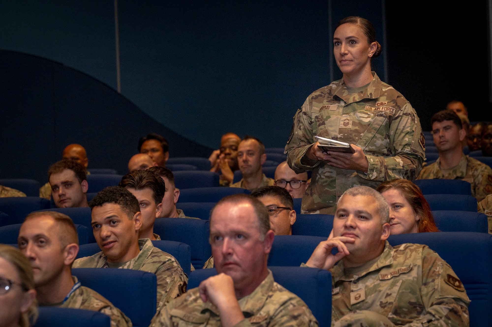 An Airman assigned to U.S. Air Forces in Europe – Air Forces Africa asks a question at an all call during Chief Master Sergeant of the Air Force David A. Flosi’s visit to Ramstein Air Base, Germany, July 22, 2025. Flosi’s visit provided opportunities for mentorship and guidance to senior enlisted, non-commissioned officers and first sergeants, fostering dialogue about the direction of the enlisted force. (U.S. Air Force photo by Senior Airman Sabrina Fuller-Judd)