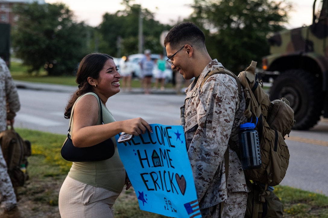 U.S. Navy Hospitalman Apprentice Kamila Benitez, left, a native of Stafford, Virginia and corpsman with 2d Battalion, 10th Marine Regiment, 2d Marine Division, greets her husband, Hospitalman Apprentice Erick Benitez-Castelan, a native of Bastrop, Texas and a corpsman with 3rd Battalion, 2d Marine Regiment, 2d MARDIV, as Marines and Sailors return from Operation Southern Guard on Marine Corps Base Camp Lejeune, North Carolina, July 24, 2025. Joint Task Force Southern Guard supported illegal alien holding operations aboard Naval Station Guantanamo Bay, Cuba led by the Department of Homeland Security. (U.S. Marine Corps photo by Lance Cpl. Brian Bolin Jr.)