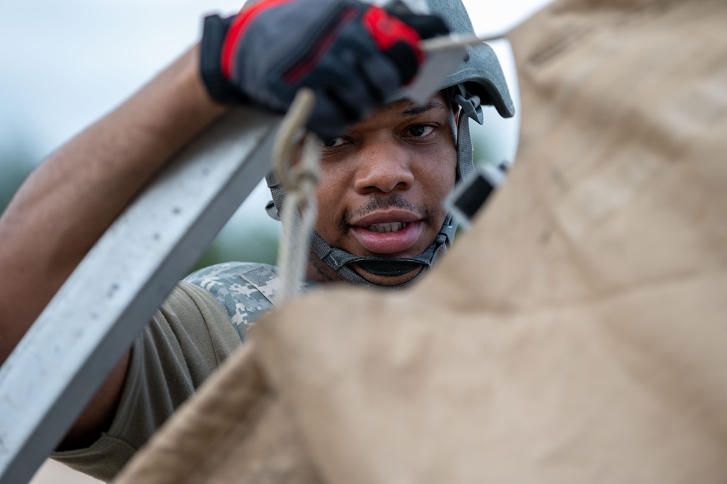 U.S. Air Force Master Sgt. Tyrell McWilliams, 786th Civil Engineering Squadron first sergeant, helps construct a tent during exercise Operation Diamondback.