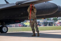 U.S. Air Force Staff Sgt. Brian Westmoreland, 9th Maintenance Squadron aircraft fuel systems repair technician, installs a pogo block onto a U-2 Dragon Lady wing prior to pogo installation at Oshkosh, Wisconsin, July 22, 2025. The pogos are used to support the wings and balance the aircraft while taxiing.