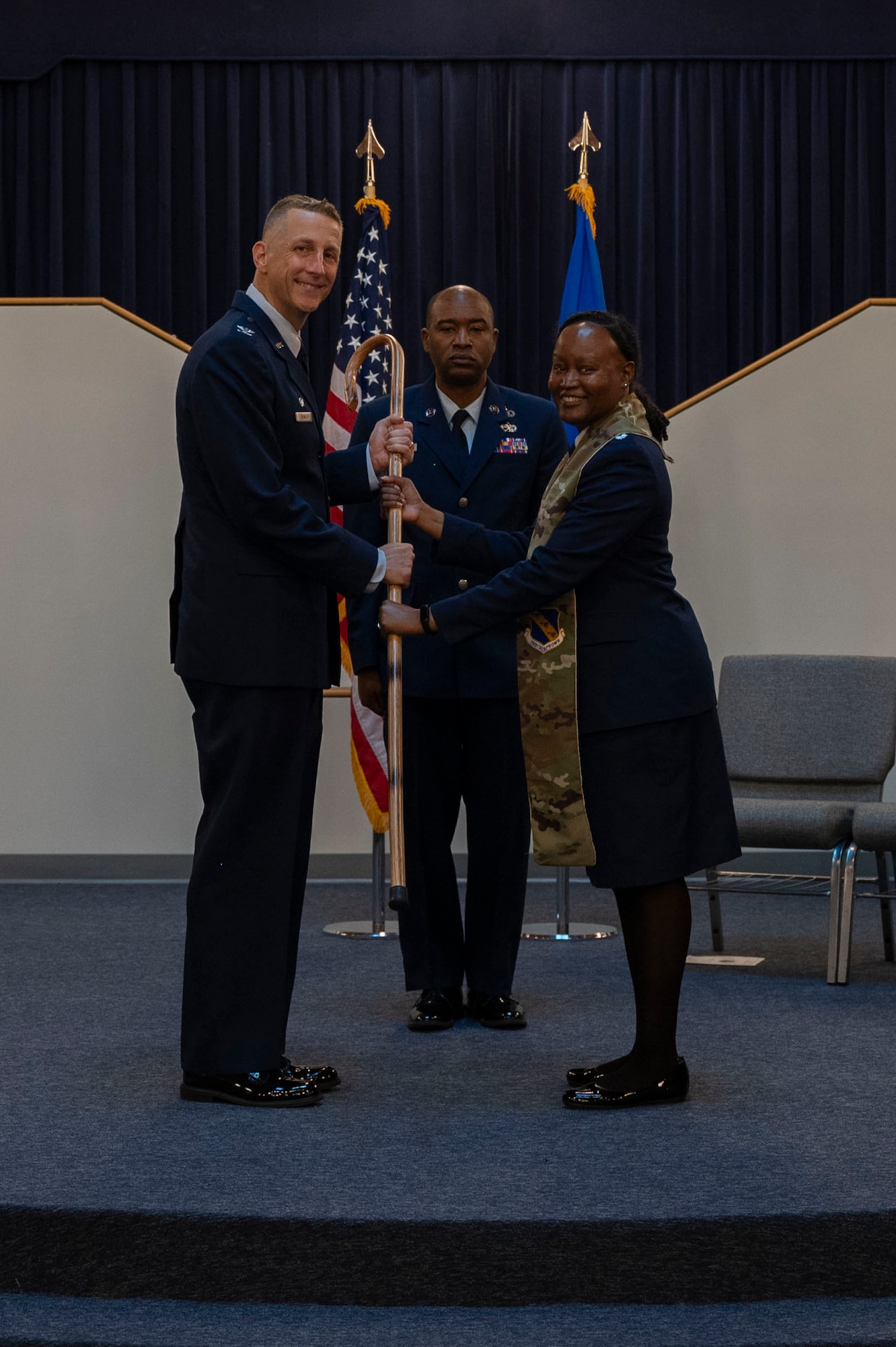 U.S. Air Force Col. Ryan A.F. Crowley, left, commander of Joint Base Anacostia-Bolling and the 11th Wing, receives a crook from Lt. Col. Meoshia Wilson, outgoing senior chaplain of the 11th WG, during a ceremony June 23, 2025.