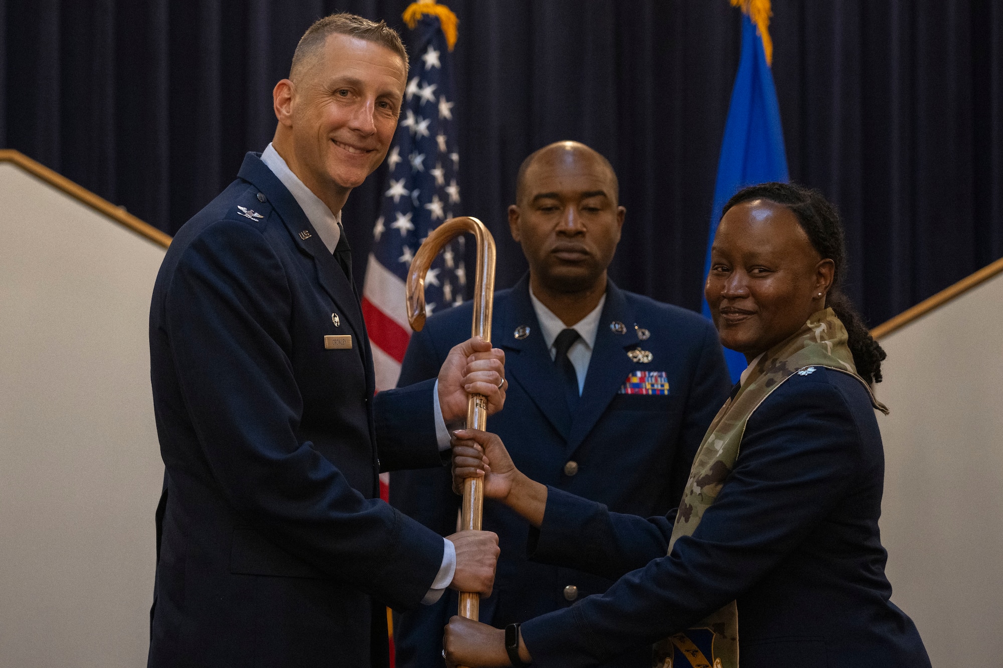 U.S. Air Force Col. Ryan A.F. Crowley, left, commander of Joint Base Anacostia-Bolling and the 11th Wing, receives a crook from Lt. Col. Meoshia Wilson, outgoing senior chaplain of the 11th WG, during a ceremony June 23, 2025.