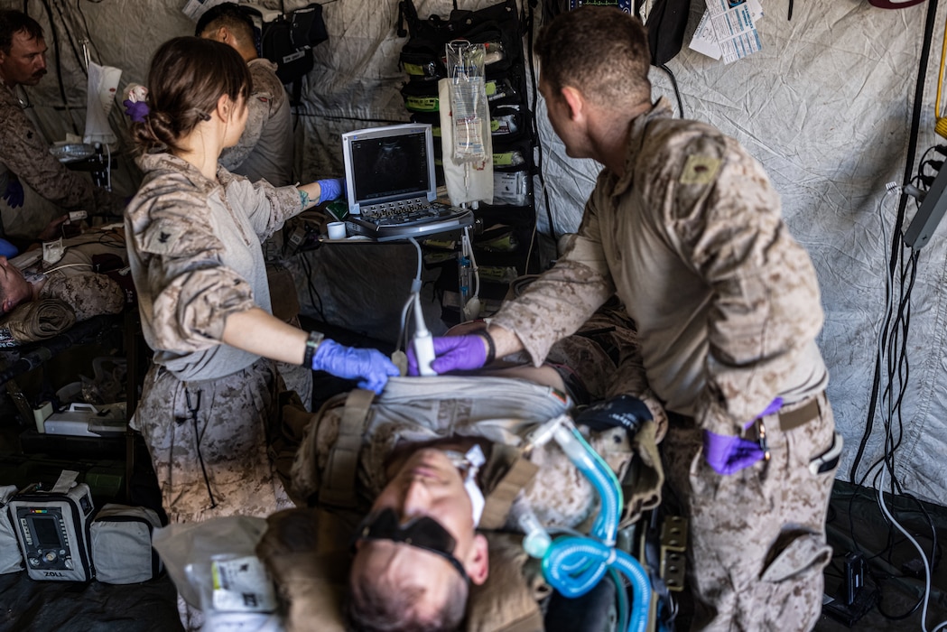 250724-M-FC877-1411 U.S. Navy Hospital Corpsman 3rd Class Madison Cira, left, a field medical service technician, and Lt. Michael Marchante, the medical service corps officer and battalion surgeon, both with Combat Logistics Battalion 8, Combat Logistic Regiment 2, 2d Marine Logistics Group, use an ultrasound system on a simulated casualty as part of damage control resuscitation drills during Service Level Training Exercise 4-25, at Marine Corps Air-Ground Combat Center, Twentynine Palms, California, July 24, 2025. SLTE 4-25 is designed to be a challenging, realistic training environment that produces combat-ready forces capable of operating as an integrated Marine Air Ground Task Force across all domains of military operations. (U.S. Marine Corps photo by Lance Cpl. Judith Ann Lazaro)
