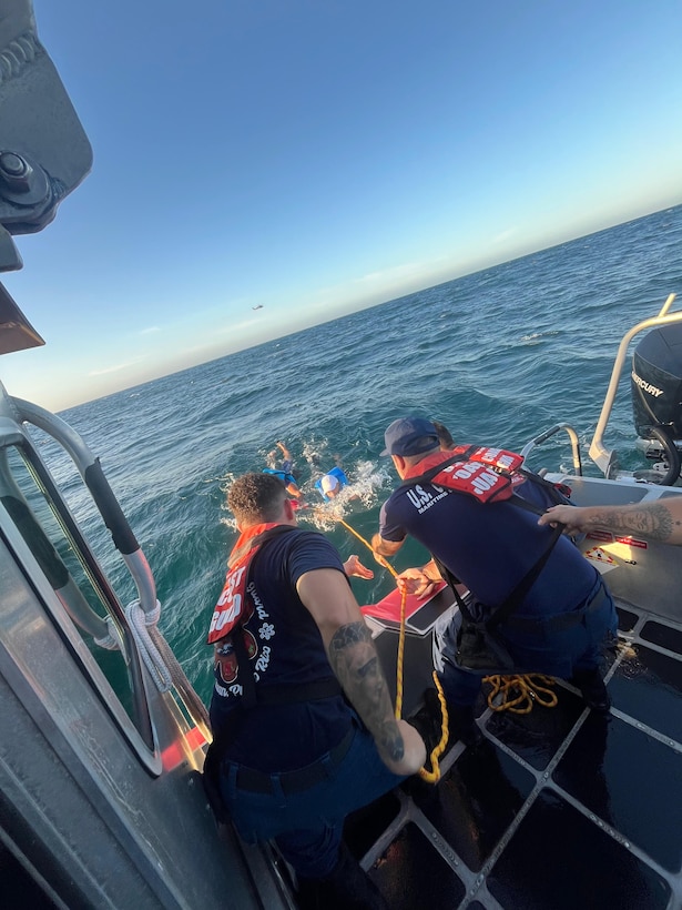 Coast Guard Station San Juan boat crew rescues three boaters from the water after they were forced to abandon their vessel that was taking on a water, approximately one nautical mile north of San Juan Harbor, July 28, 2025.  The Coast Guard boat crew worked with a Puerto Rico Police Marine unit to bring the boaters and the distressed vessel to safe harbor. (U.S. Coast Guard photo)