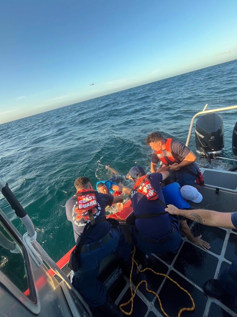 Coast Guard Station San Juan boat crew rescues three boaters from the water after they were forced to abandon their vessel that was taking on a water, approximately one nautical mile north of San Juan Harbor, July 28, 2025.  The Coast Guard boat crew worked with a Puerto Rico Police Marine unit to bring the boaters and the distressed vessel to safe harbor. (U.S. Coast Guard photo)