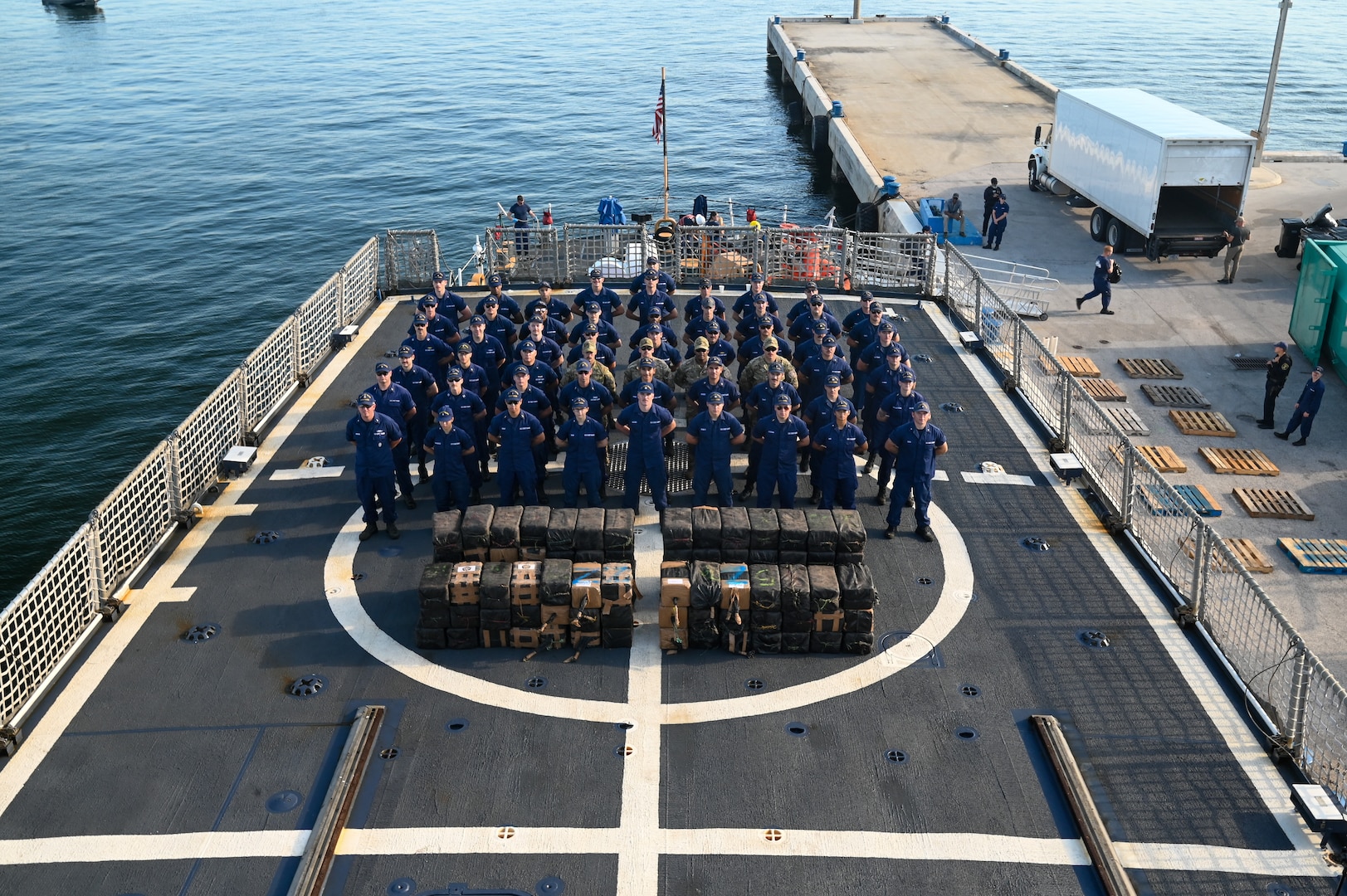 The crew of the Coast Guard Cutter Tahoma standing at parade rest on the flight deck at Port Everglades, Florida, July 29, 2025. The seized contraband was the result of an interdiction on June 24, 2025, approximately 120 miles northwest of Ecuador. (U.S. Coast Guard photo by Petty Officer 3rd Class Nicholas Strasburg)