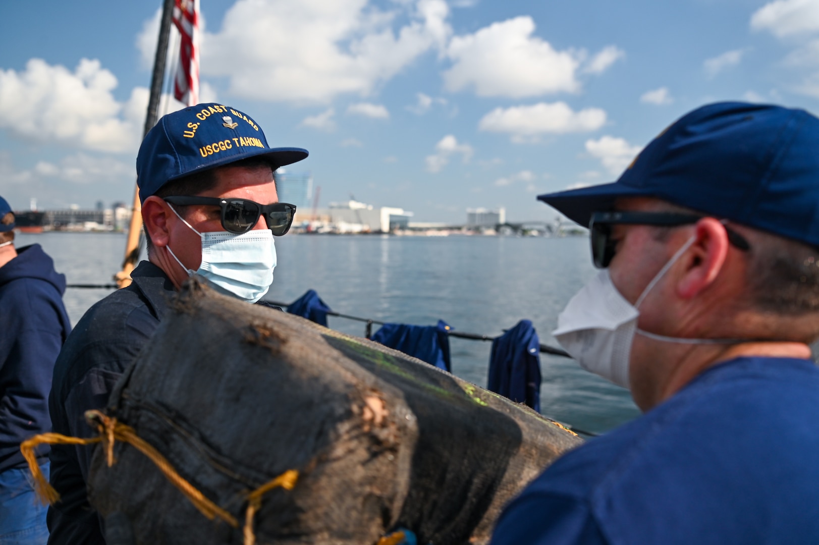 The crew of the Coast Guard Cutter Tahoma passing bales of cocaine off-board during an offload at Port Everglades, Florida, July 29, 2025. The seized contraband was the result of an interdiction on June 24, 2025, approximately 120 miles northwest of Ecuador by the crew of the Tahoma. (U.S. Coast Guard photo by Petty Officer 3rd Class Nicholas Strasburg)