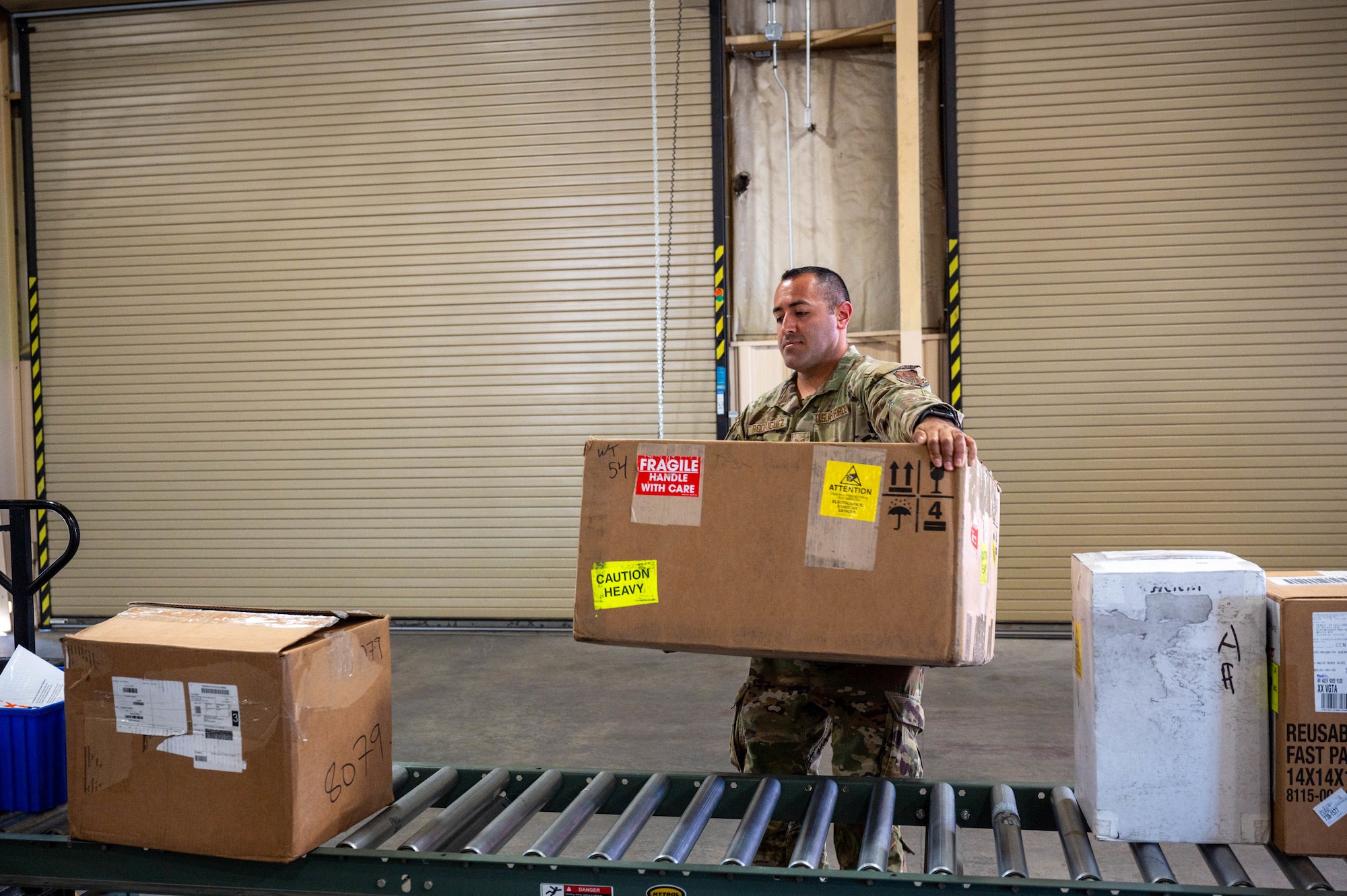 Staff Sgt. Noel Rodriguez Alvarez, 419th Logistics Readiness Squadron traffic management office craftsman, carries an incoming package during his annual tour at Nellis Air Force Base, Nev., July 28, 2025.