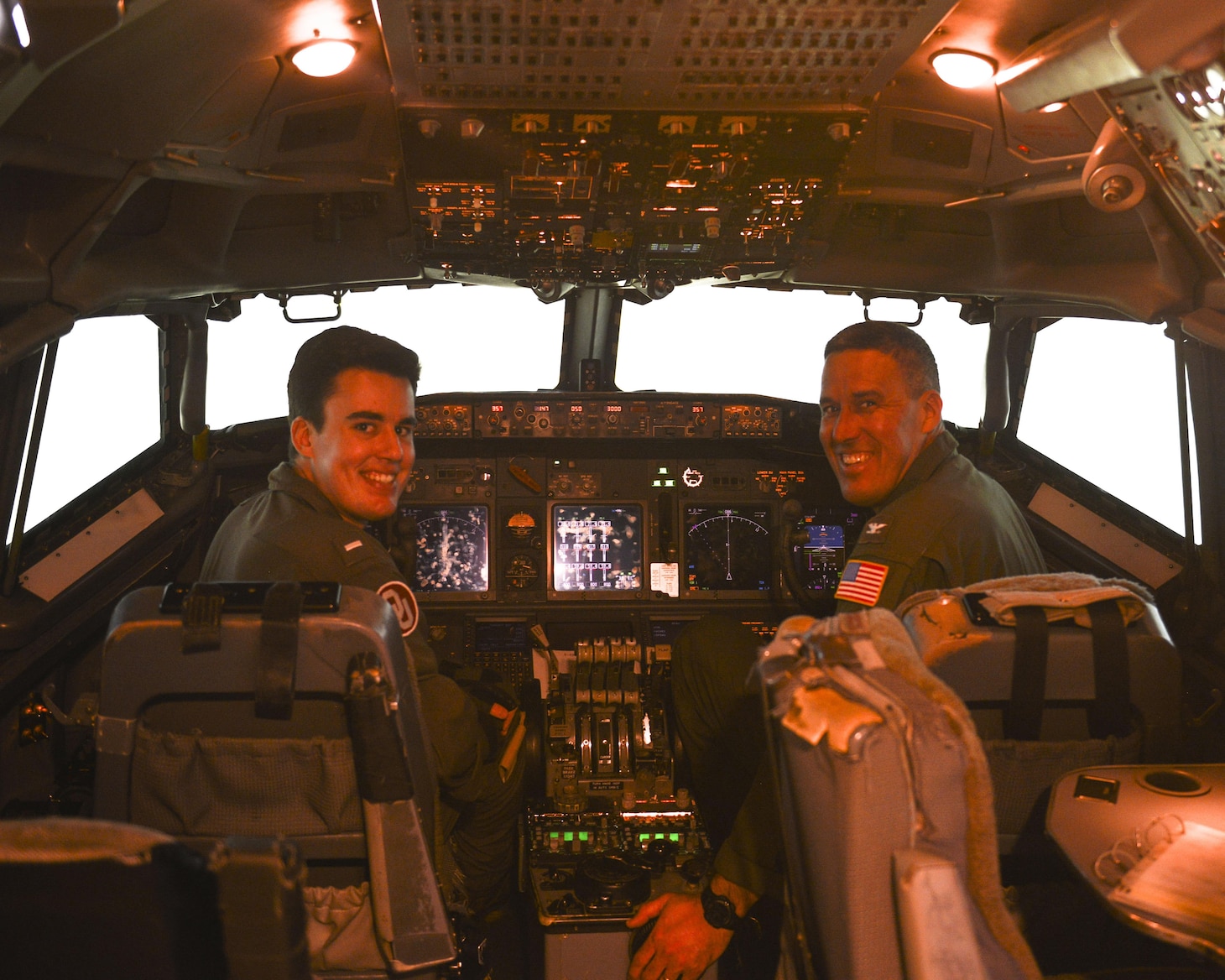 Lt. j.g. Scott (left) showcases his knowledge to his father, Capt. Scott (right), in the E-6 simulator at Tinker Air Force Base.