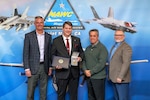 Clint Stammer (holding medal), F-35 Joint Program Office Electronic Attack & Countermeasures lead, poses with Pat Schuett (far left), Gerardo Garcia (second from right), and Tom Dowd (far right) following an award ceremony at Point Mugu, California, April 1. Stammer received the Office of the Secretary of Defense Exceptional Civilian Service medal, the highest honor awarded to career Department of Defense civilians.