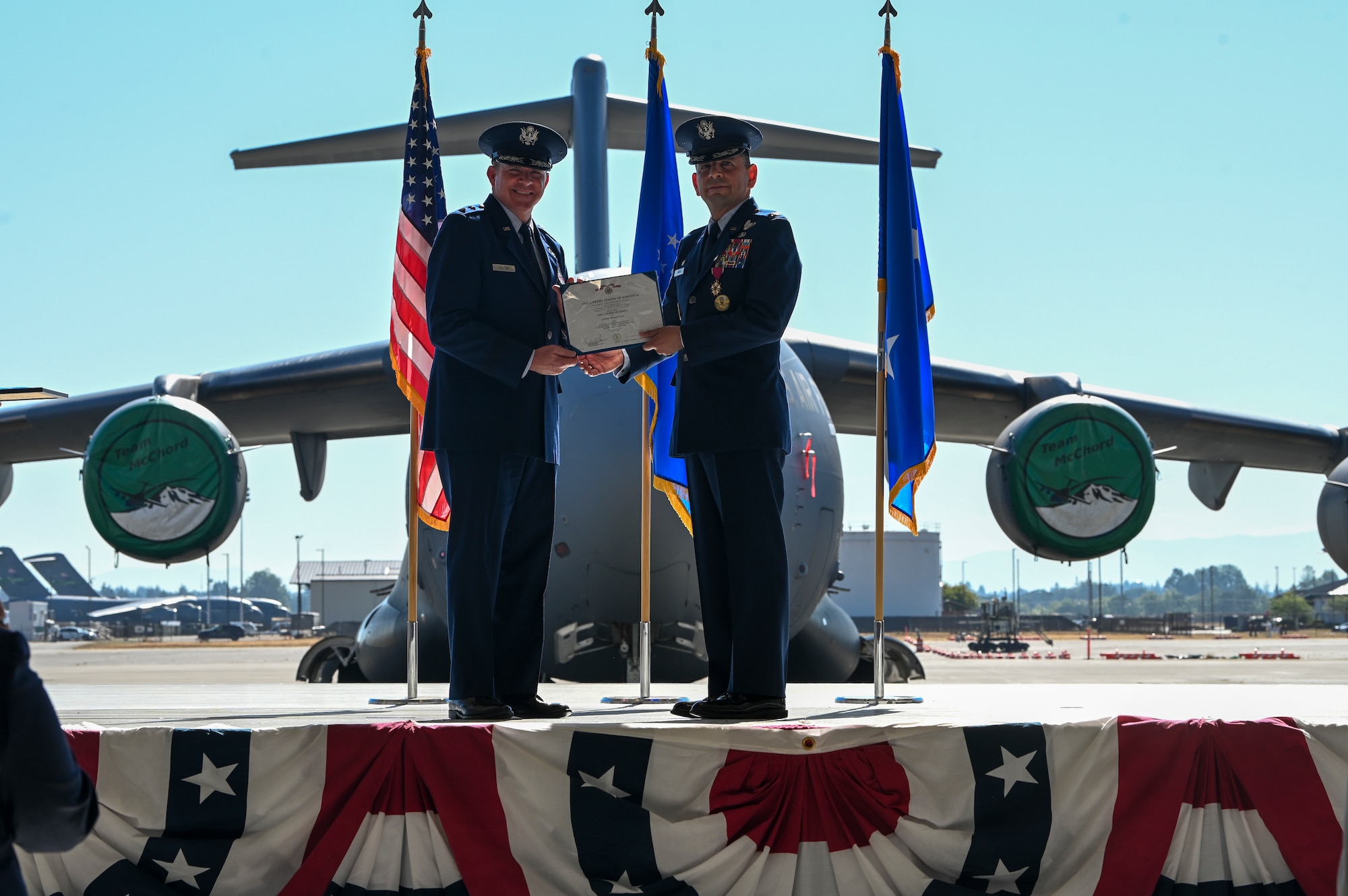 U.S. Air Force Col. Sergio Anaya, right, outgoing 62d Airlift Wing commander, receives the Legion of Merit from Maj. Gen. Charles Bolton, Eighteenth Air Force commander, during a change of command ceremony at Joint Base Lewis-McChord, Washington, July 29, 2025.
