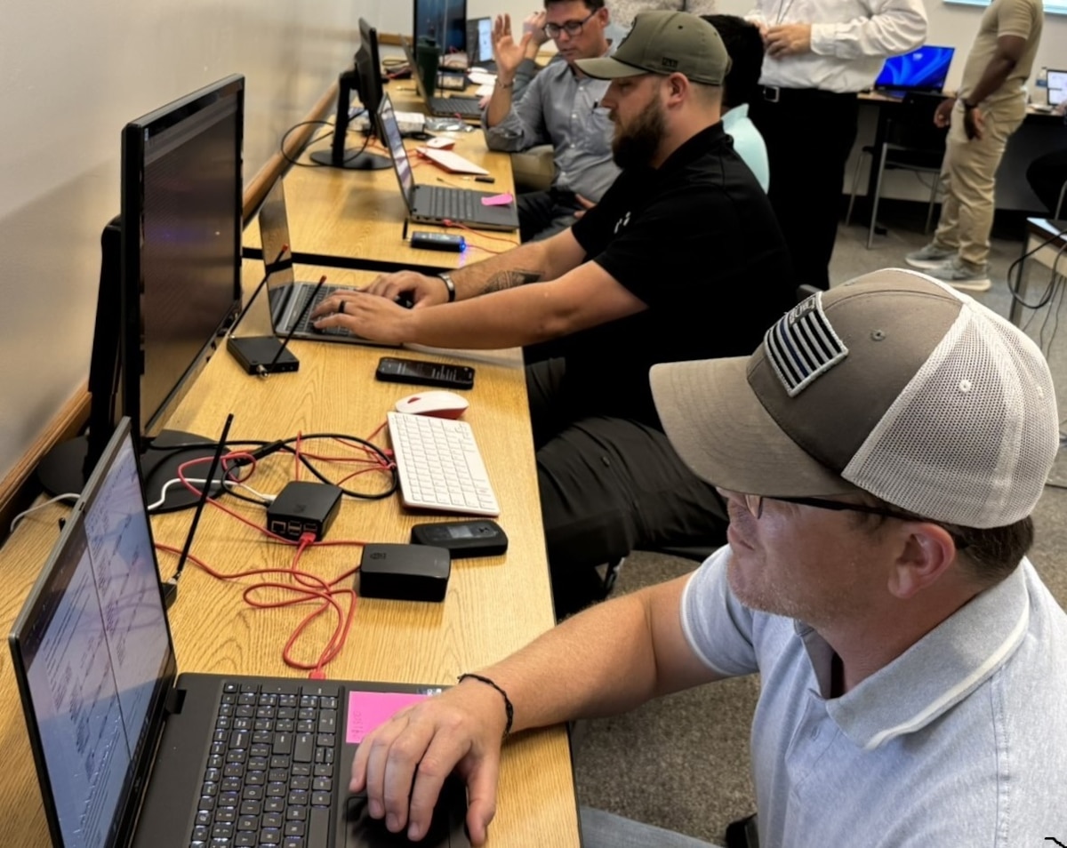 Side profile of participants sitting in front of laptop computers.