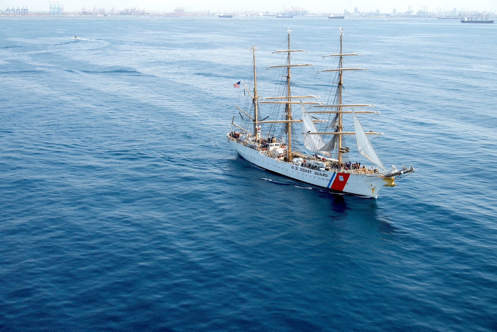 The U.S. Coast Guard Cutter Eagle, seen from inside a Coast Guard MH-60T Jayhawk helicopter, departs Los Angeles Harbor on May 26, 2025. The Coast Guard uses the Eagle to train cadets and officer candidates, teaching them practical seamanship skills while indoctrinating them in the Coast Guard’s afloat leadership laboratory. The Eagle moored for Los Angeles Fleet Week 2025, where cadets led public tours of the ship and participated in morale events with other branches of the military to reinforce teamwork. (Coast Guard photo by Petty Officer First Class J.J. Huggins)