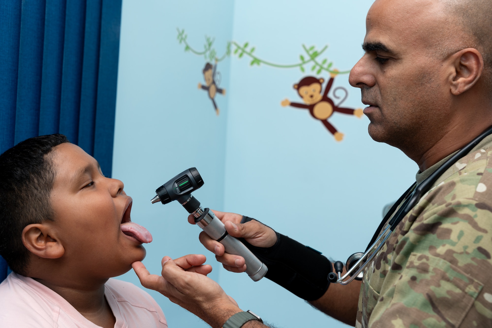 U.S. Air Force Lt. Col. Niyasdeen Dieguez, 482nd Medical Squadron pediatrician, performs a pharyngeal exam on a child during a community health event in Santa Ana, El Salvador, June 24, 2025. The event was a component of AMISTAD 2025, an Air Forces Southern led campaign that brings U.S. medical professionals to Latin American countries to work with host nation counterparts and help improve regional capacity to respond to health challenges. (U.S. Air Force photo by Staff Sgt. Joshua Hastings)