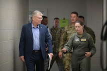 Secretary of the Air Force walks with Airmen down a hallway.
