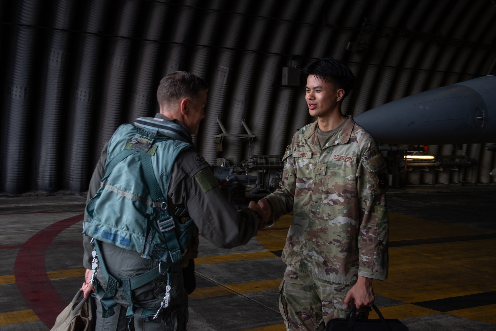 A pilot shakes hands with a maintainer upon arriving at an F-16.