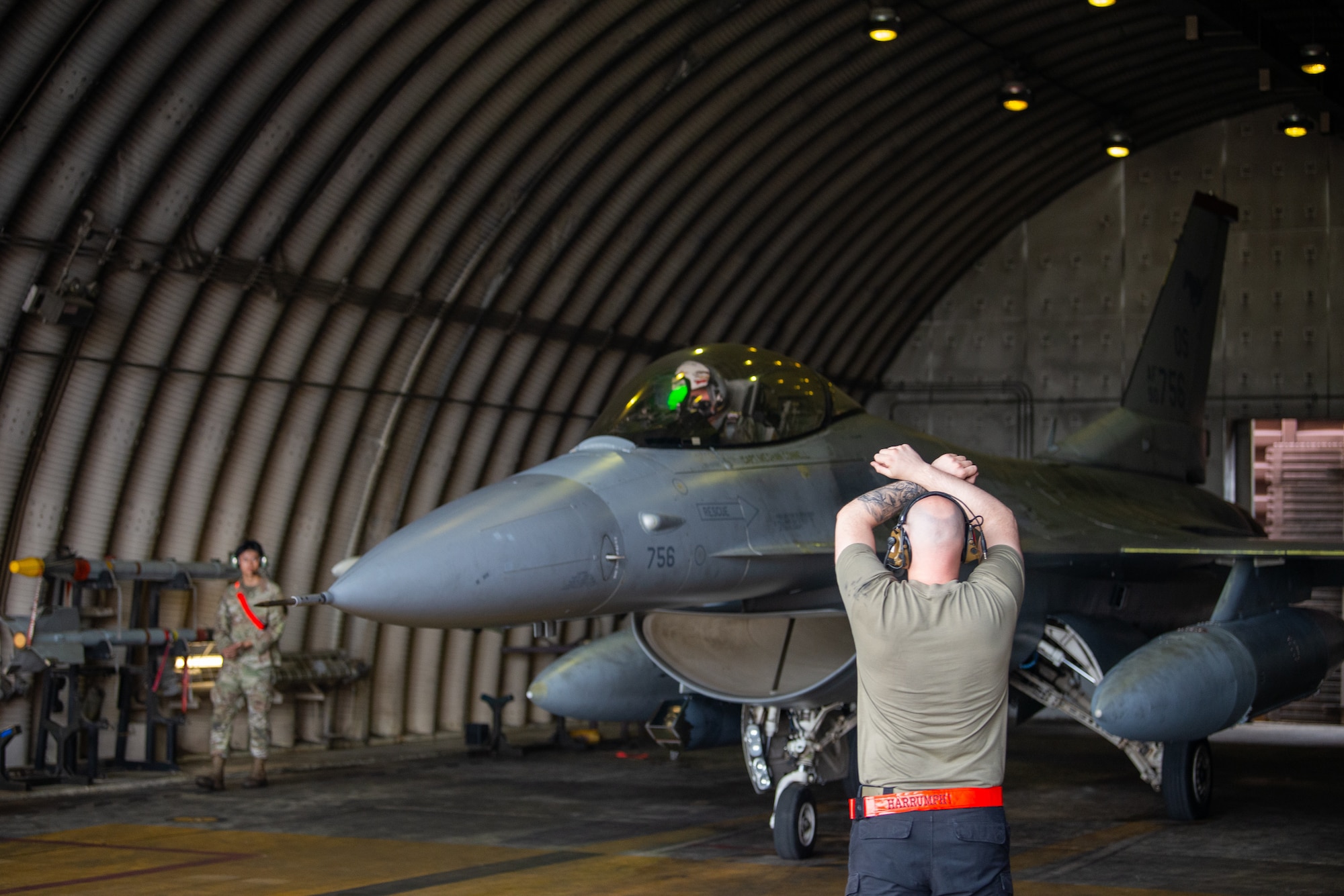A maintainer marshals an F-16.