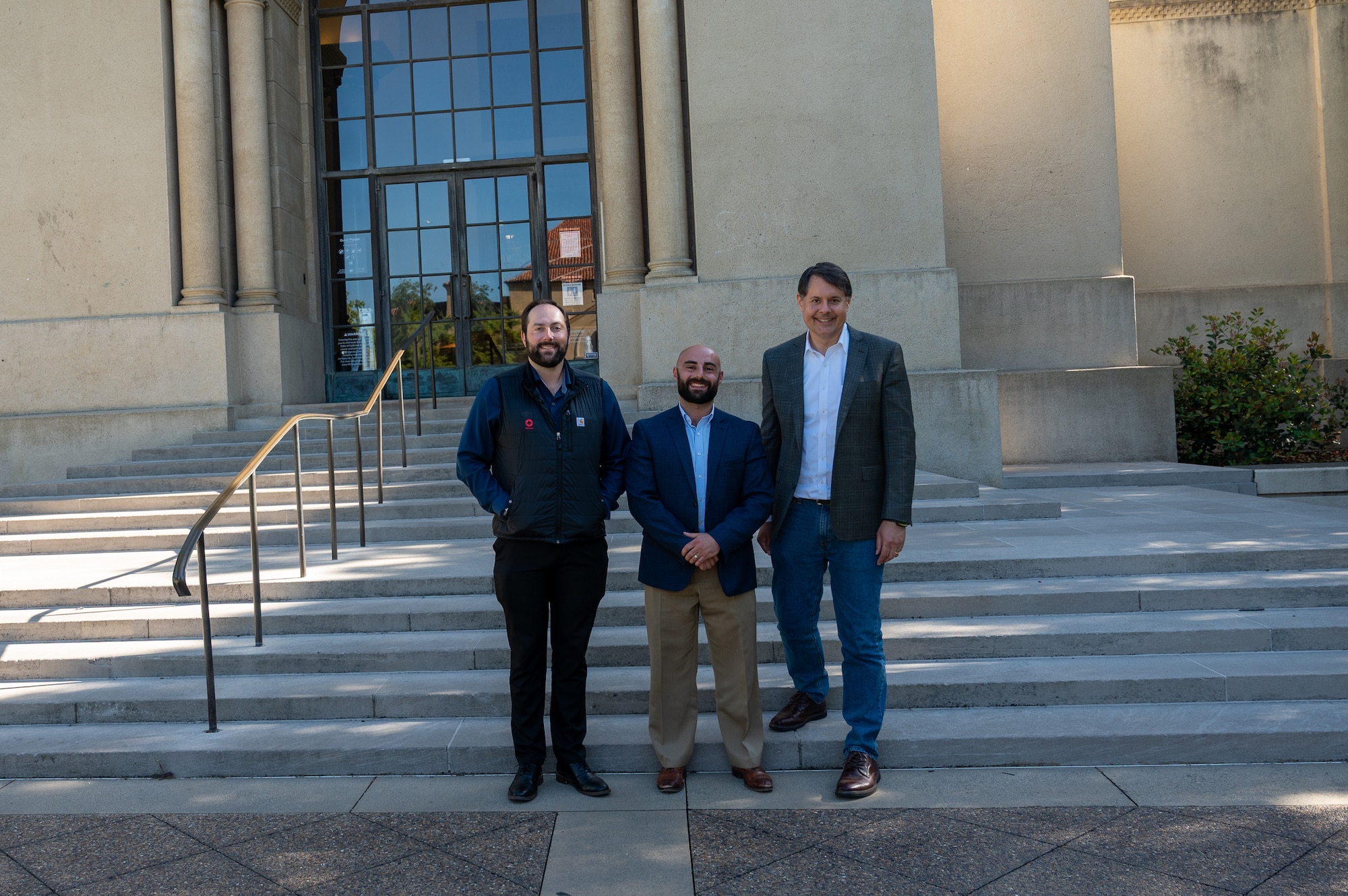From right, Special Agent Dante Tabarracci, Special Agent Kevin Alexander, and Dr. Glenn Tiffert pose outside the Hoover Institution at Stanford University, May 14, 2025.