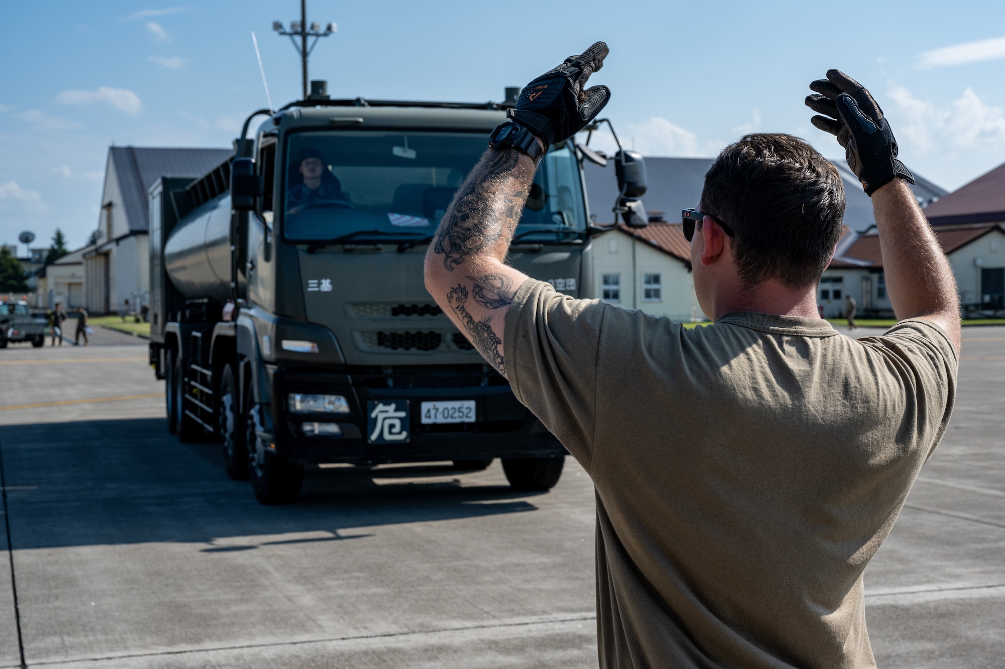 U.S. Air National Guard Senior Airman Brenden Wassmer, 106th Rescue Wing helicopter crew chief, guides a fuel truck during exercise Resolute Force Pacific (REFORPAC) 2025 at Misawa Air Base, Japan, July 16, 2025.